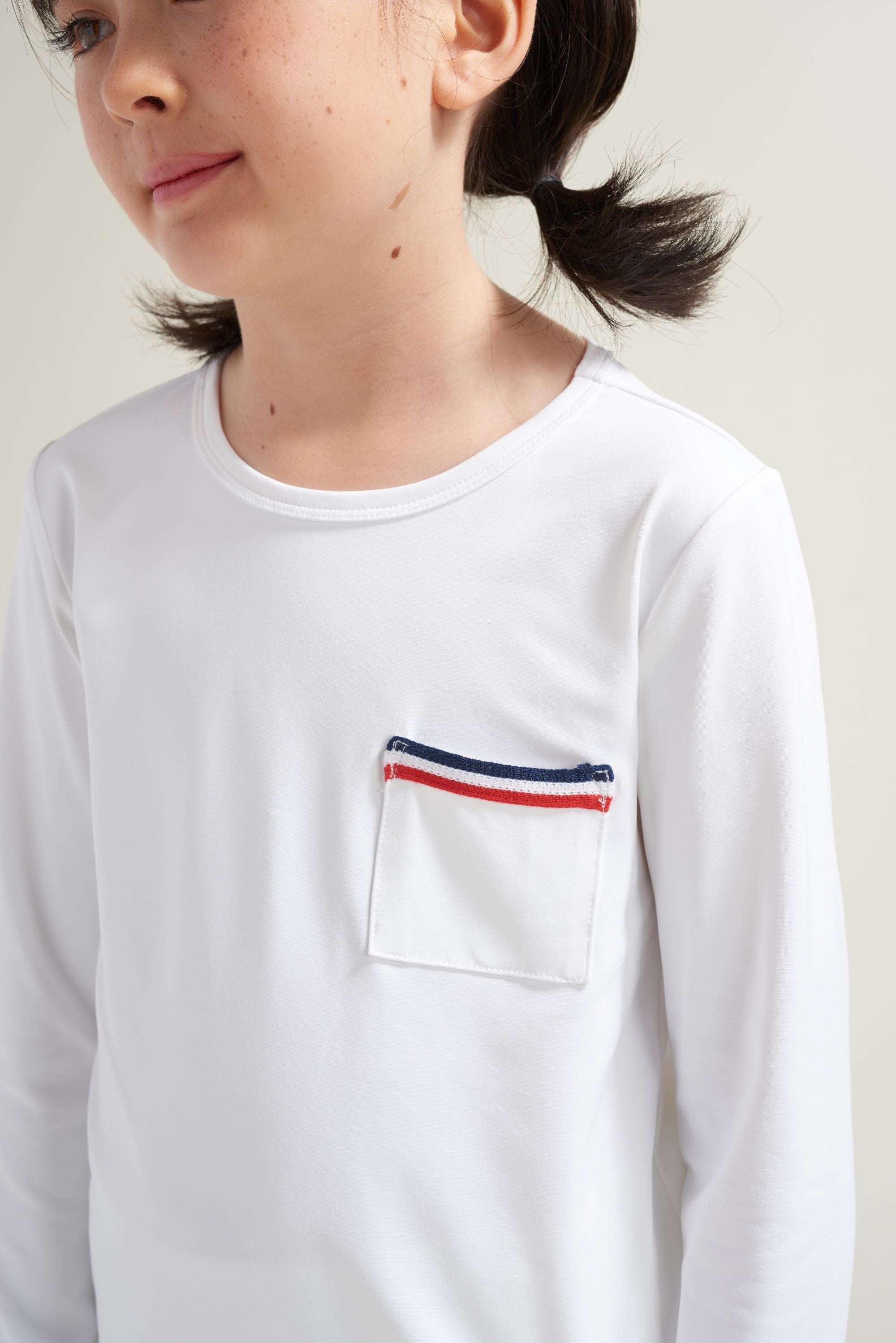 Bright white long sleeve tennis shirt with chest pocket and red and blue trim.