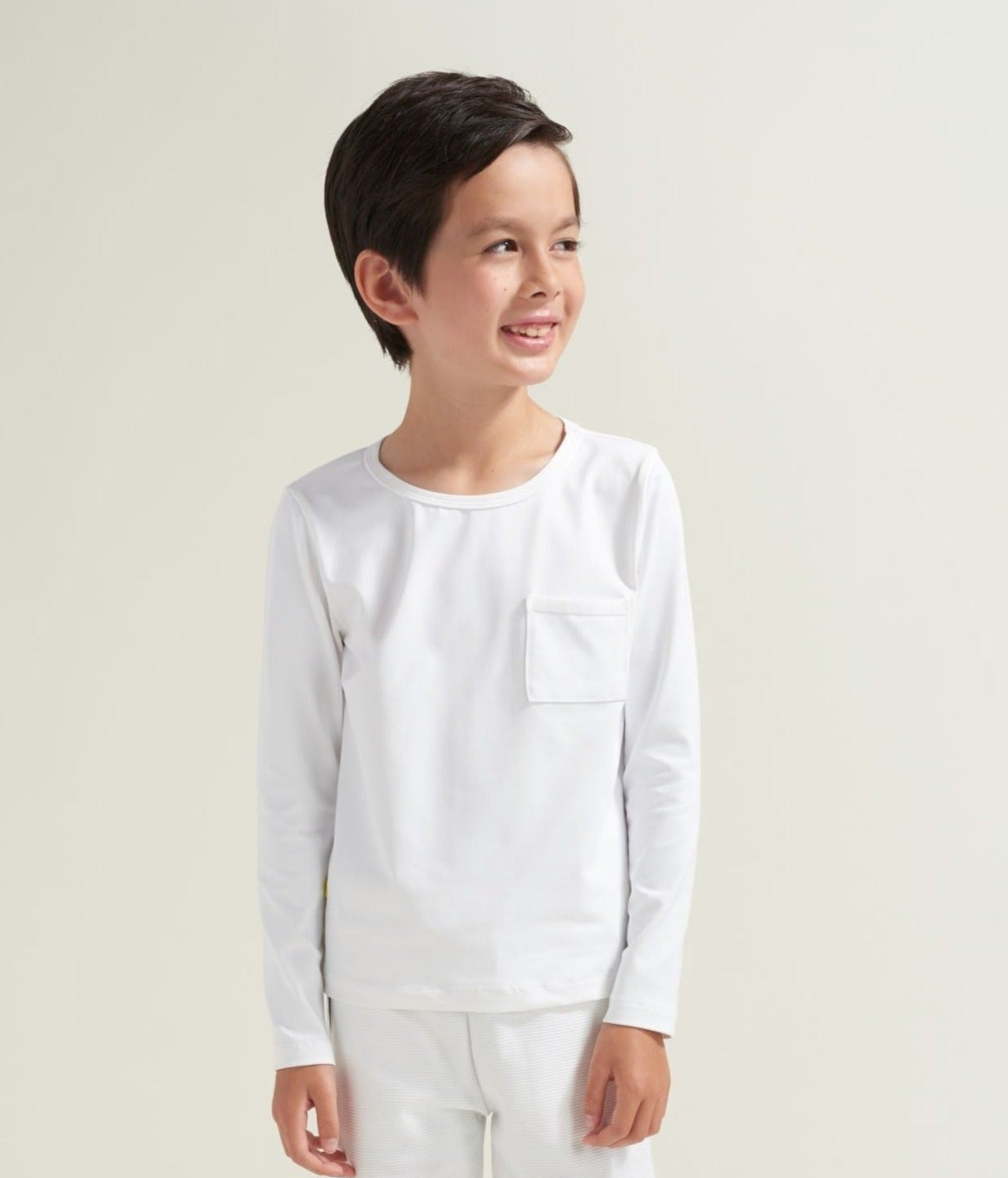 Youth tennis athlete is wearing a long sleeve tennis t-shirt in all white.