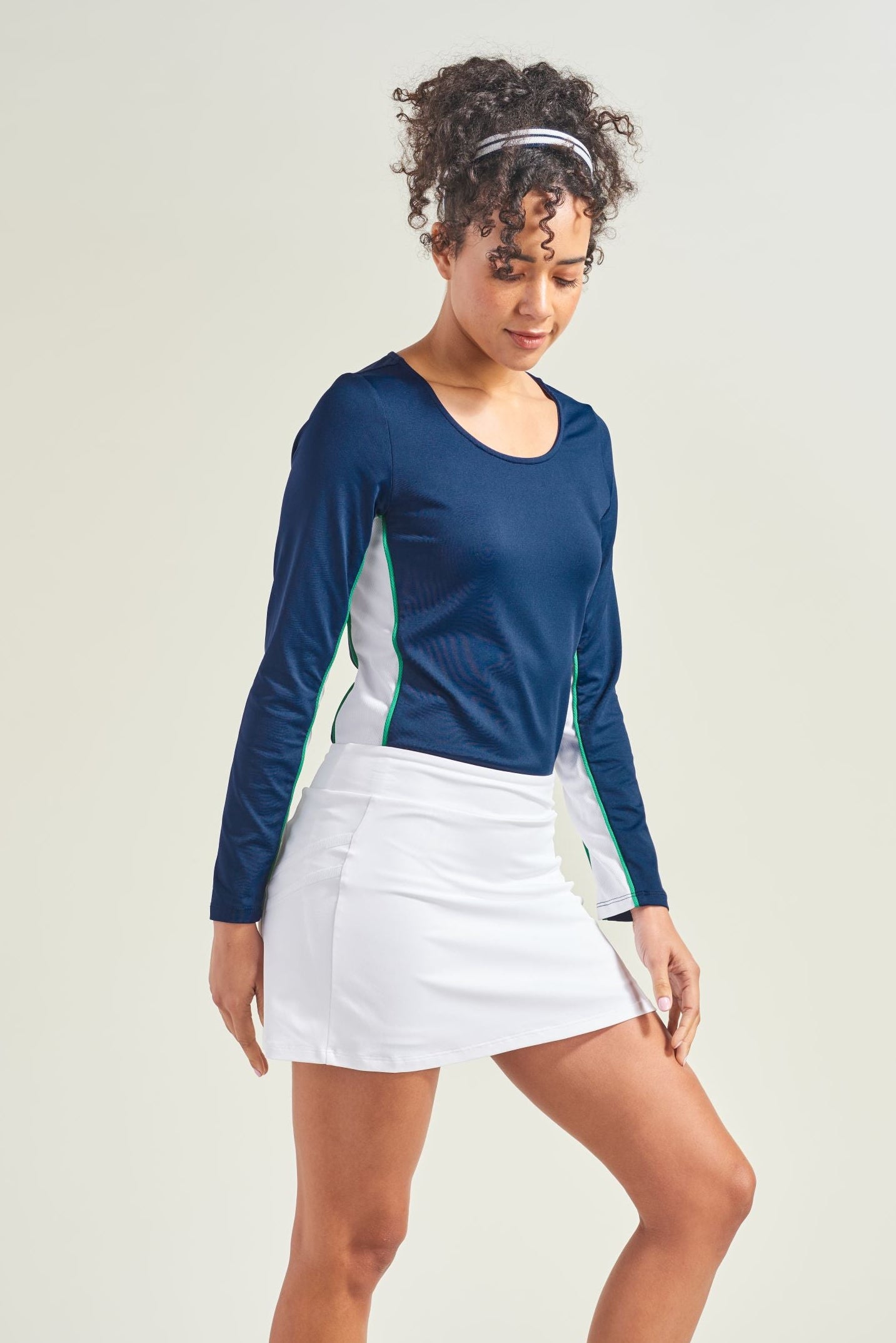 Women's all white tennis skort with navy tennis long sleeve shirt.