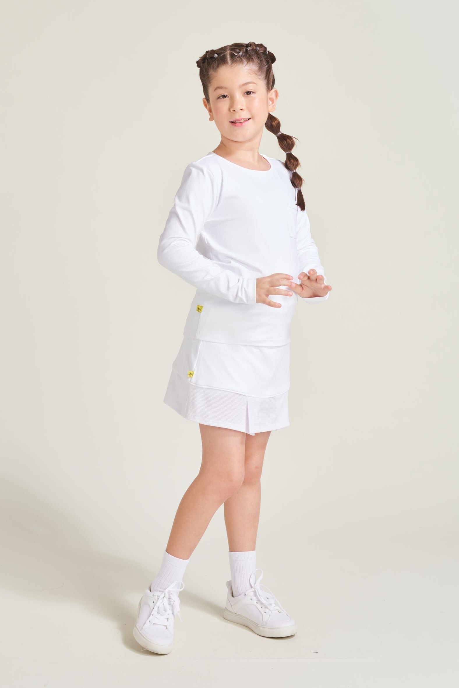 Tennis athlete wearing youth girls all white tennis matching set.