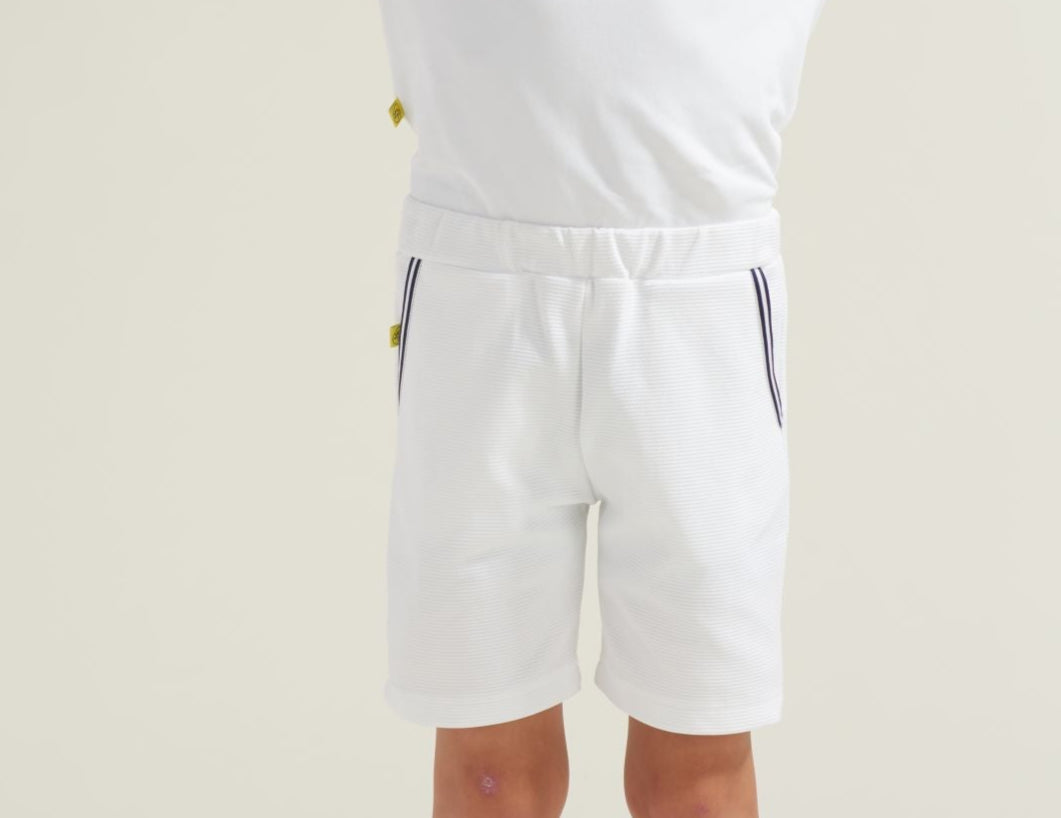 Boys' tennis athlete wearing youth white tennis shorts with navy and white trim along pockets.