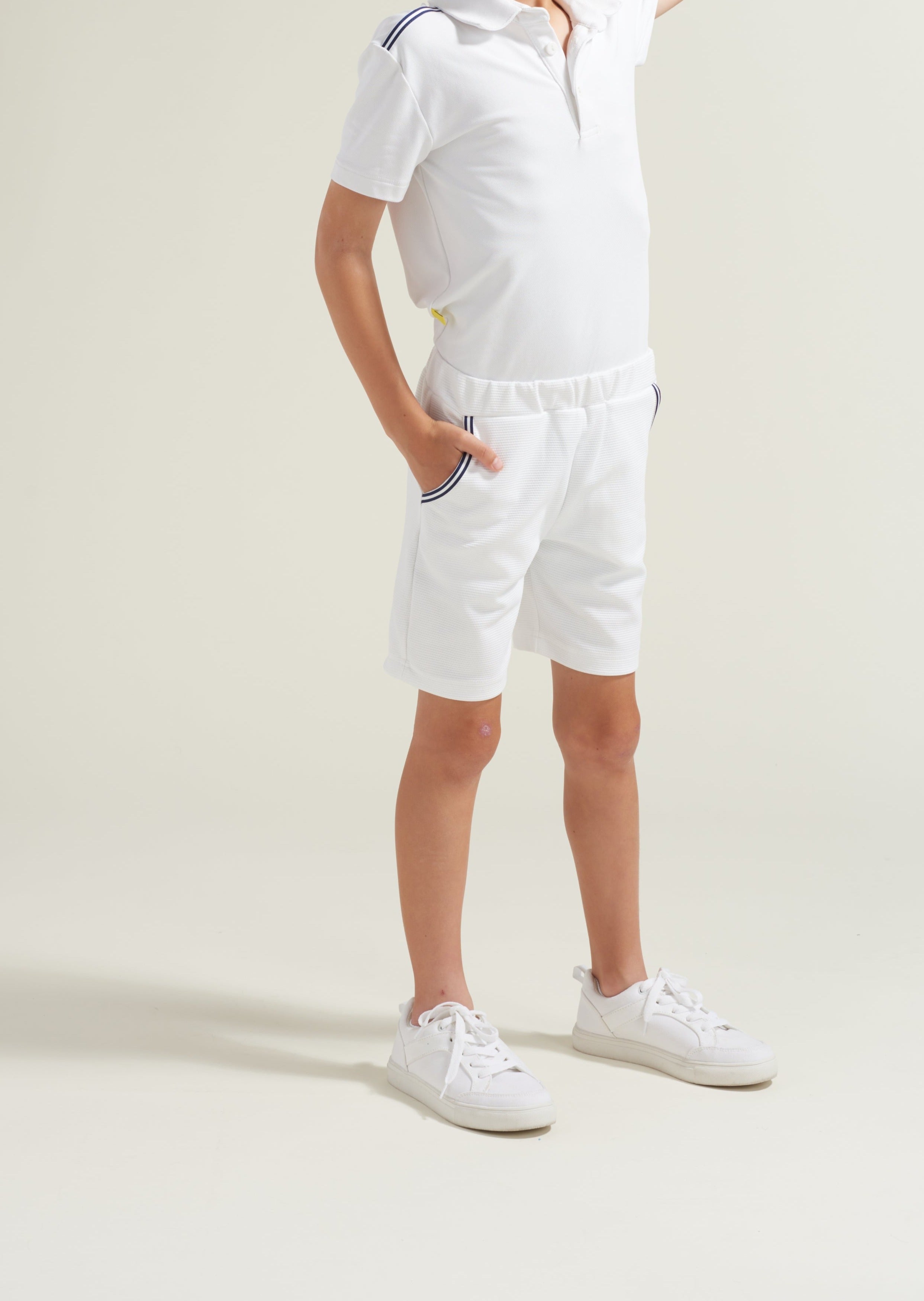 Boys' tennis athlete wearing youth white tennis shorts with navy and white trim along pockets.