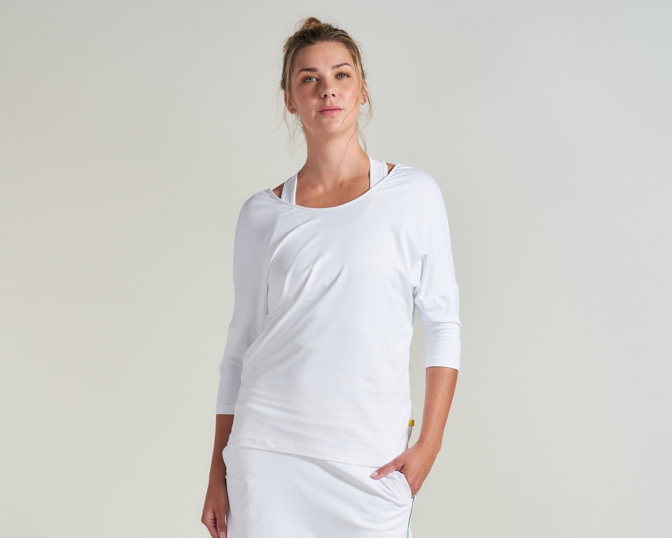 All white tennis three quarters shirt with matching undershirt for women.