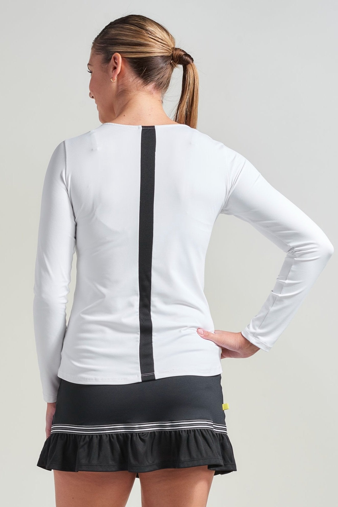 Back view of white tennis shirt with black mesh stripe along back.