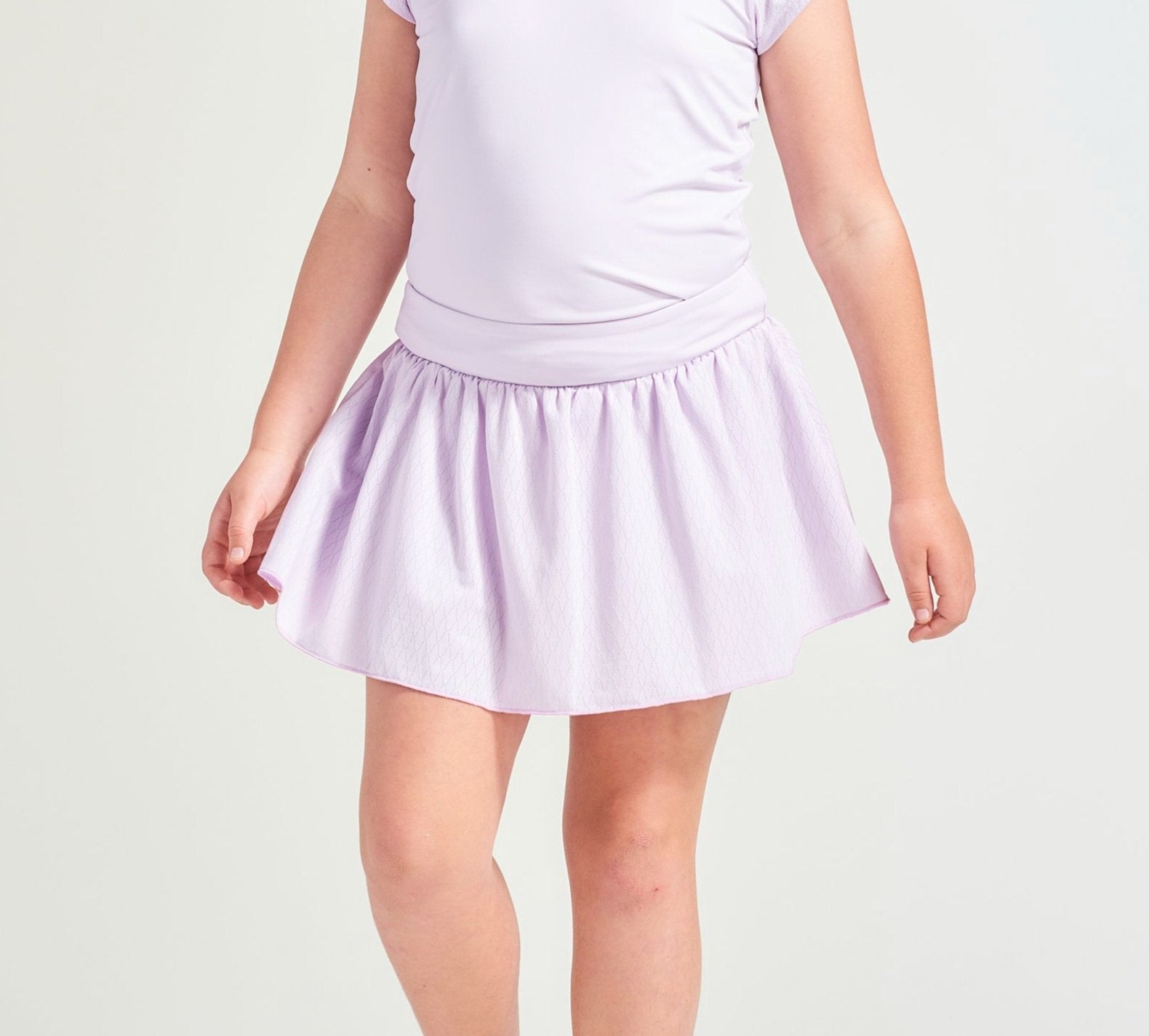Lavender kid's tennis clothes with tennis skort and tennis t-shirt.