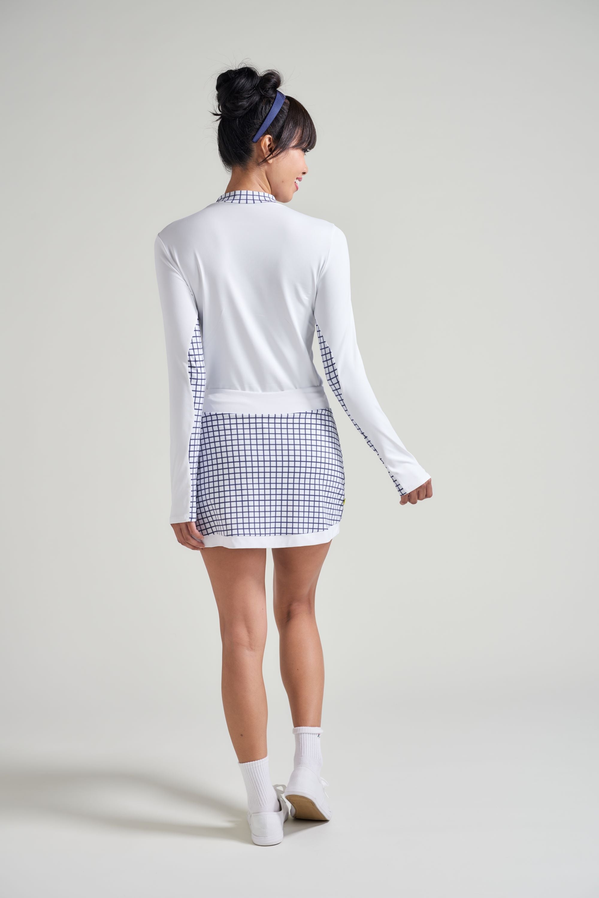 Back view of navy checkered tennis skort with matching long sleeve tennis shirt