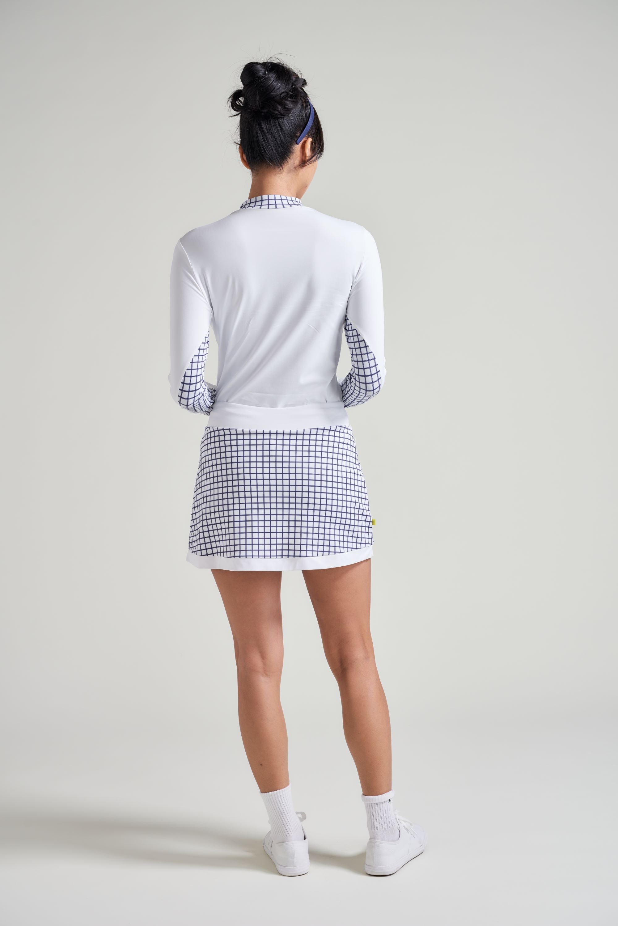 Back view of long sleeve workout shirt with navy checkered print for women