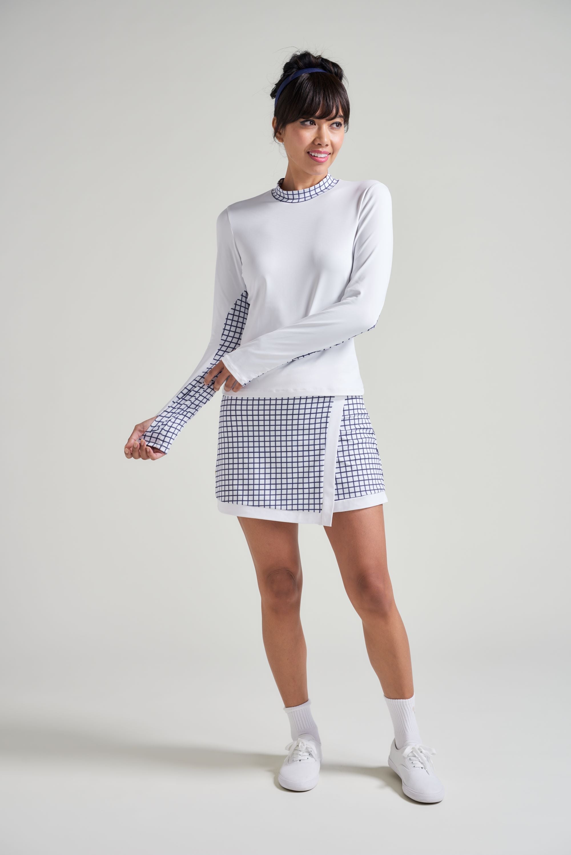 Tennis athlete wearing matching tennis set in white with navy white accents.
