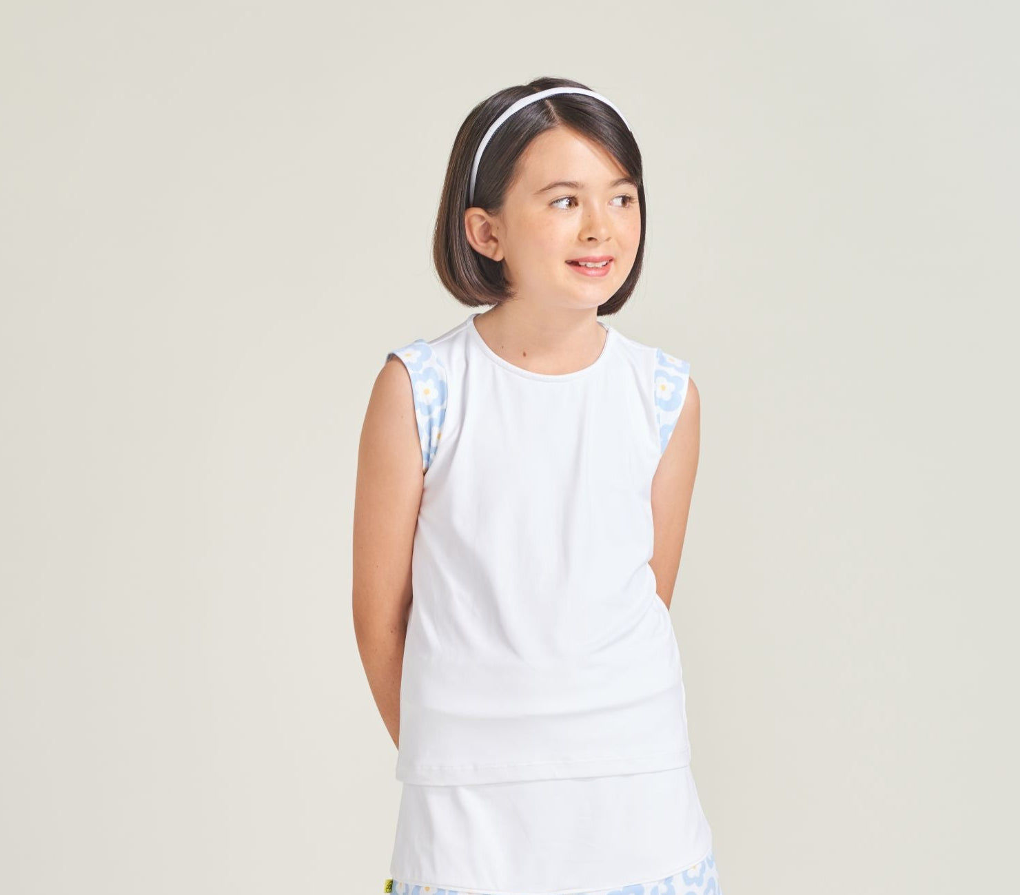 Tennis athlete wearing a girls' tennis shirt with flower print cap sleeves.