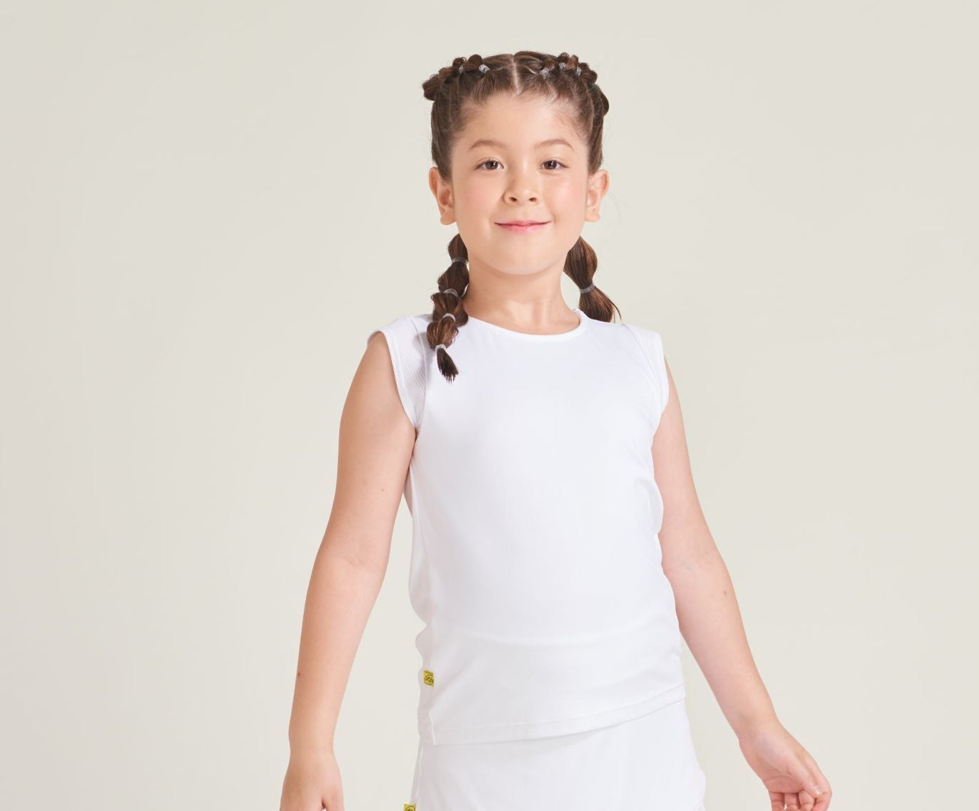 Youth tennis girl wearing a tennis t-shirt with cap sleeves in all white.