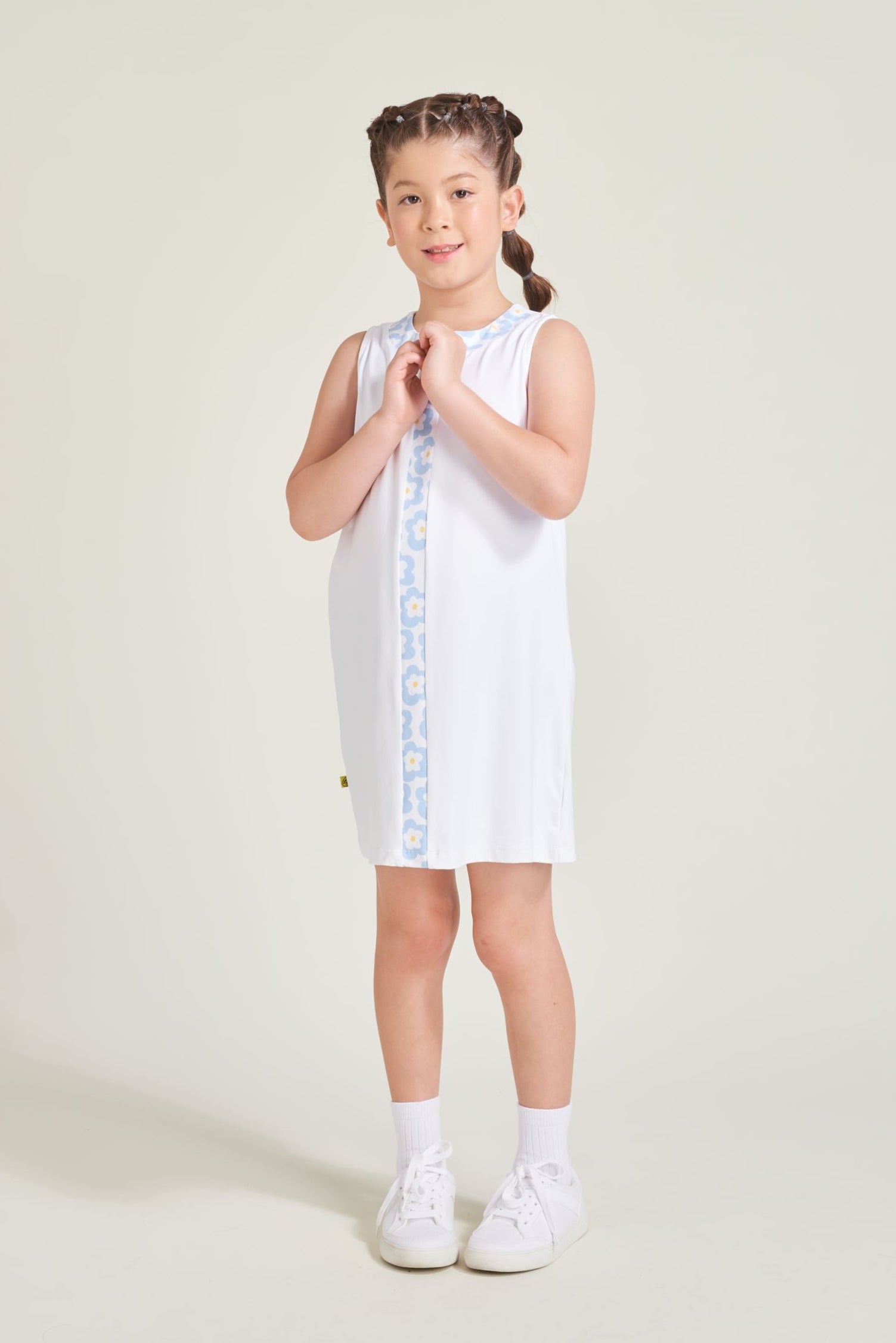 Girls athlete wearing white shift tennis dress with flower print contrast.