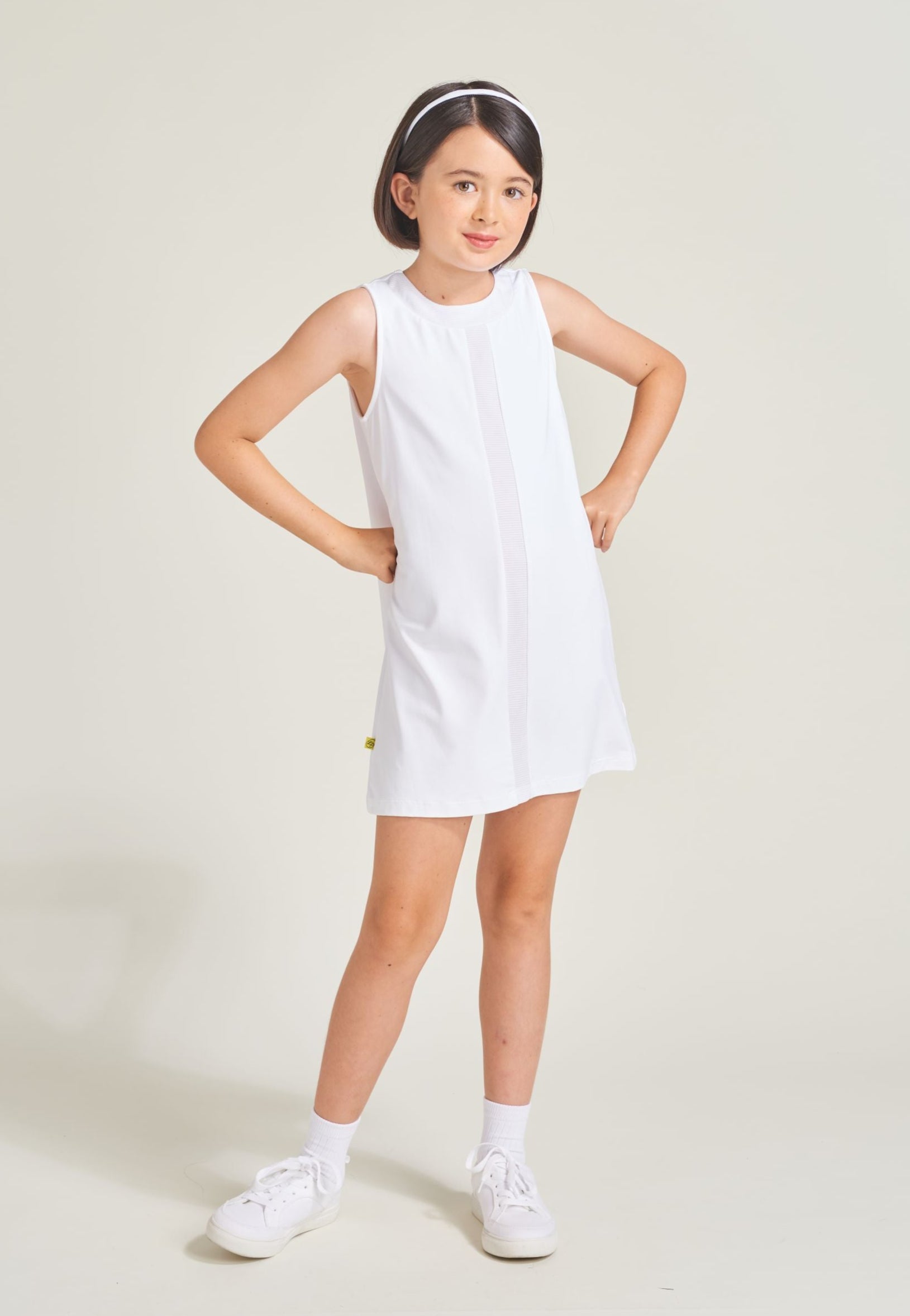 Girls' tennis athlete wearing white tennis dress for girls.