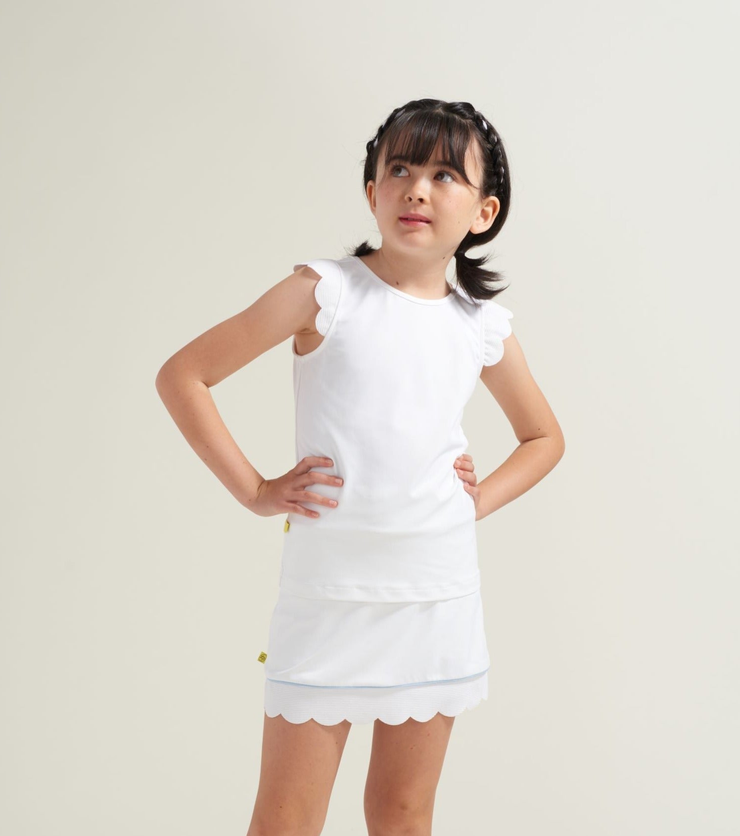 Youth girls all white tennis tank with scalloped sleeves.