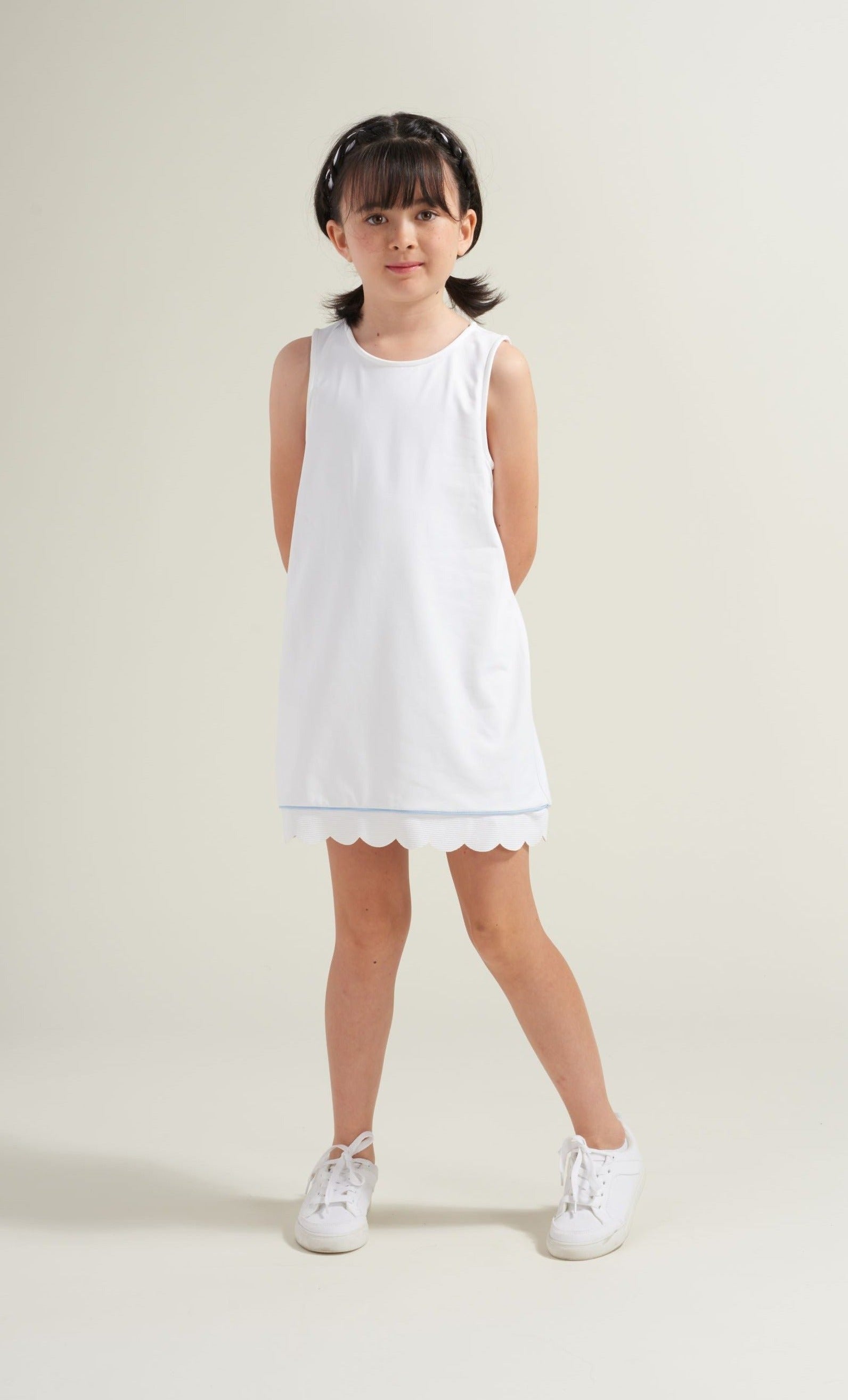 Girls' tennis player wearing white tennis dress with blue accent piping.