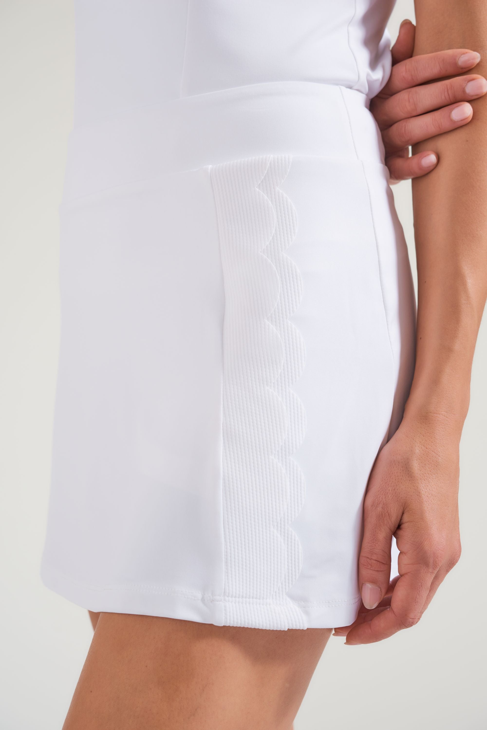 Side view of women's tennis all white tennis skort with double scalloped edge