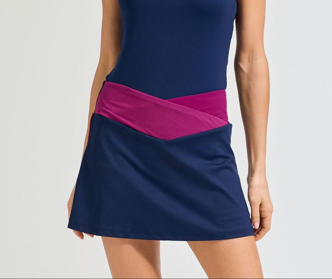 Women's tennis skort in navy with burgundy crossover waistband.