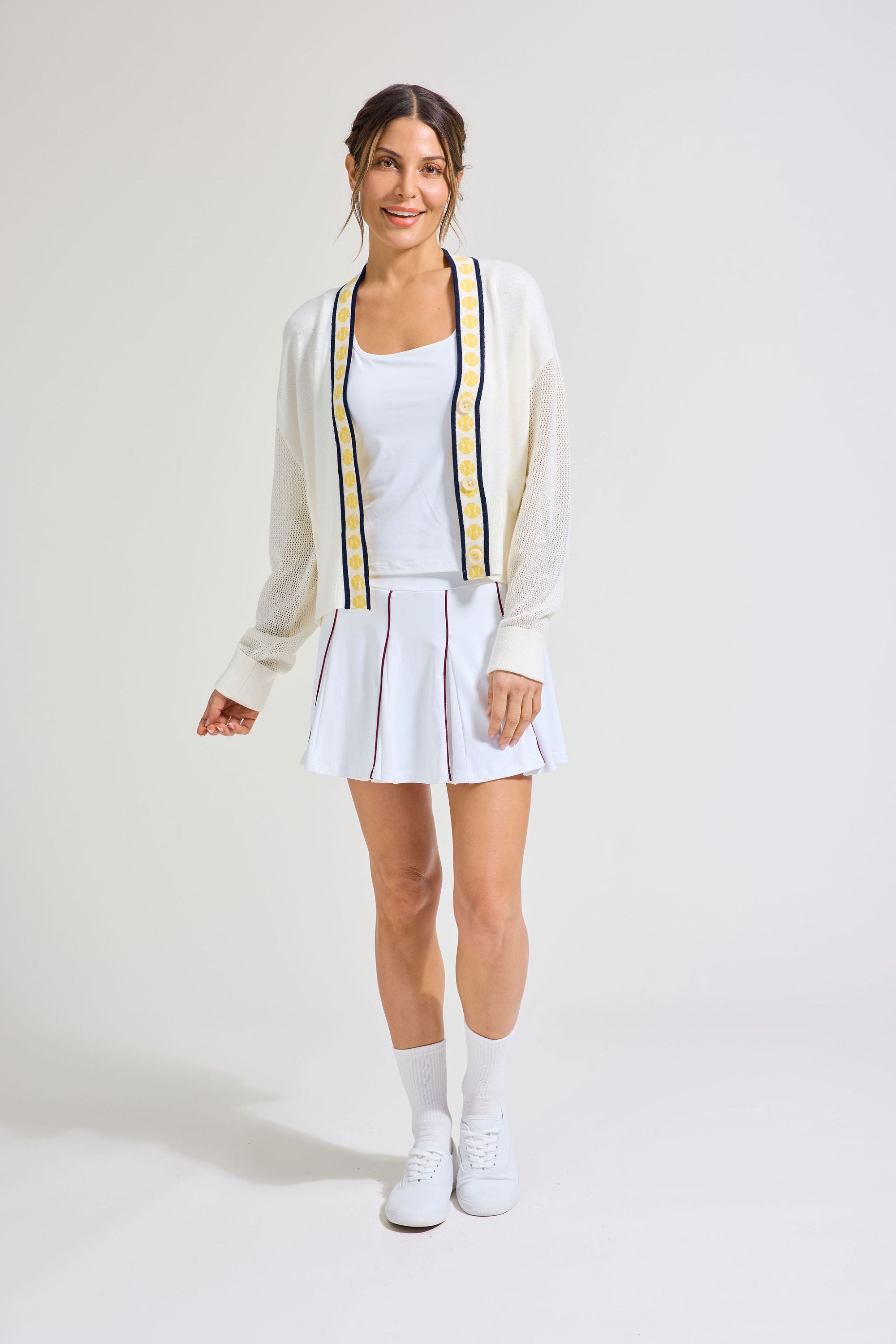 Women's tennis player wearing all white tennis outfit.