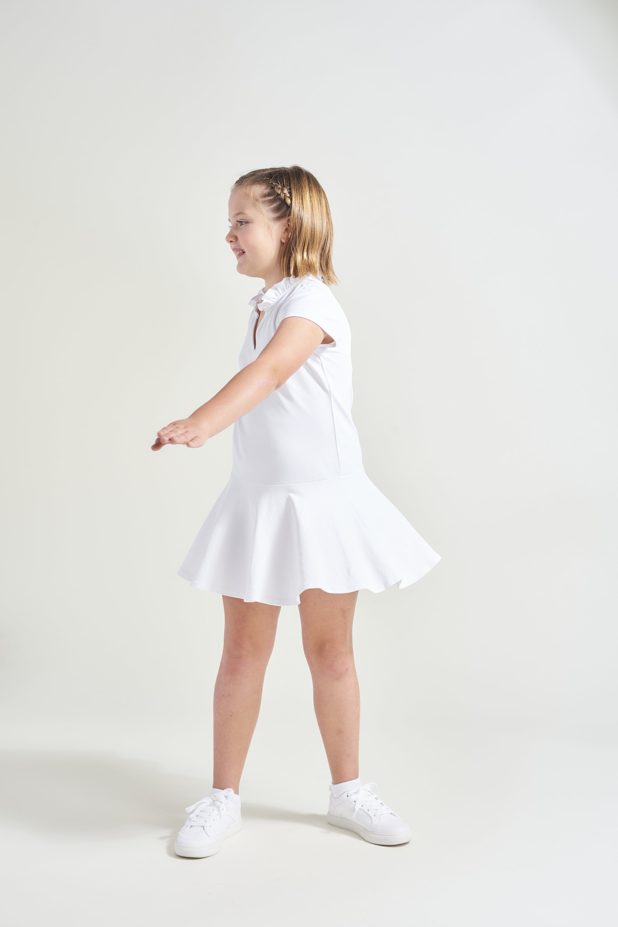 Girls tennis player is wearing tennis dress in white.