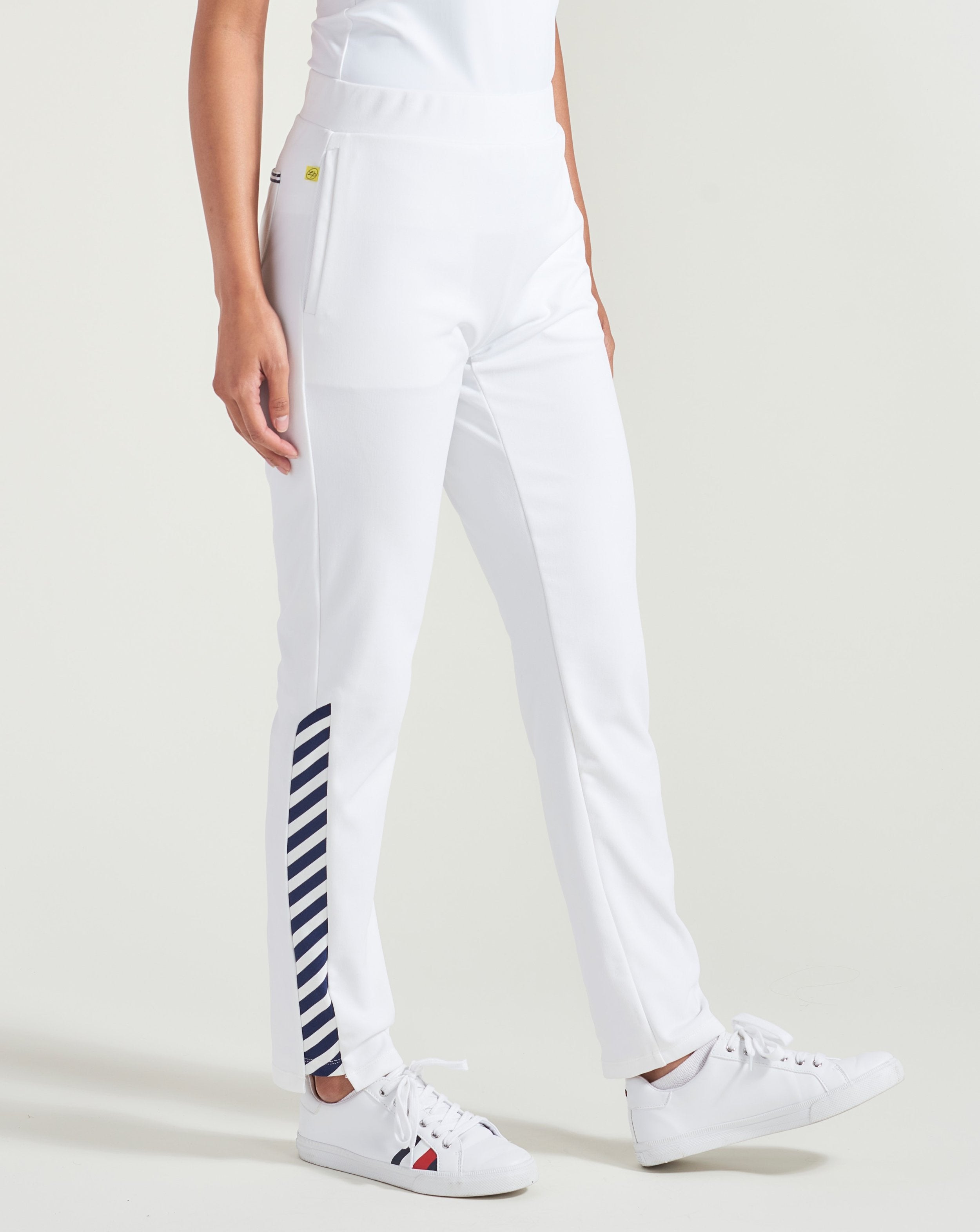 Women's white warm up pants with navy accent trim.