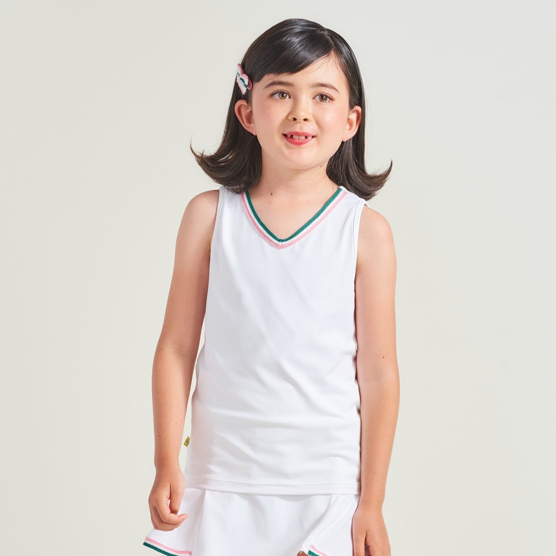 White tennis tank tops for kids with pink and green trim along neckline