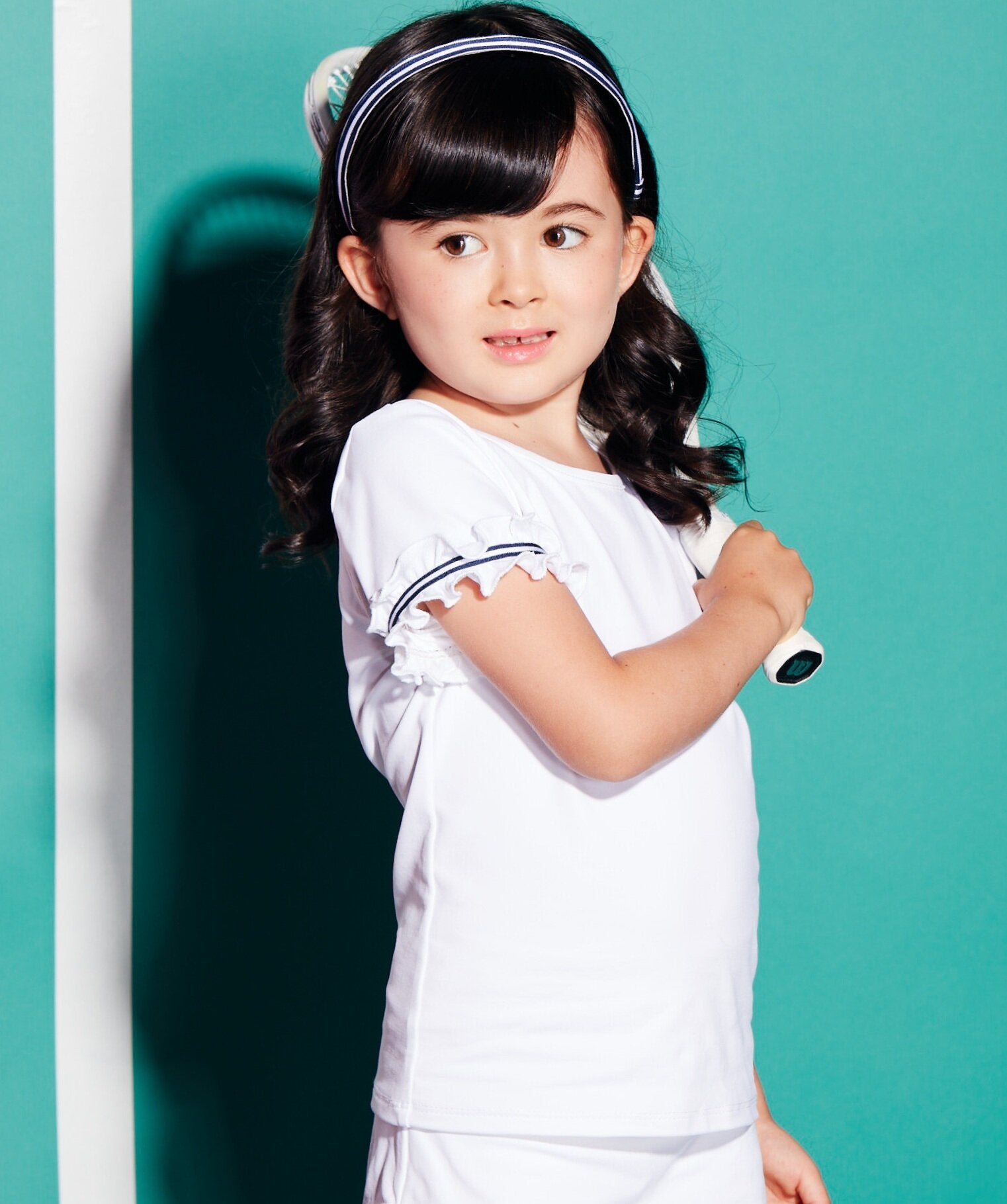 All white tennis shirt for kids with navy and white trim detail on shoulder.