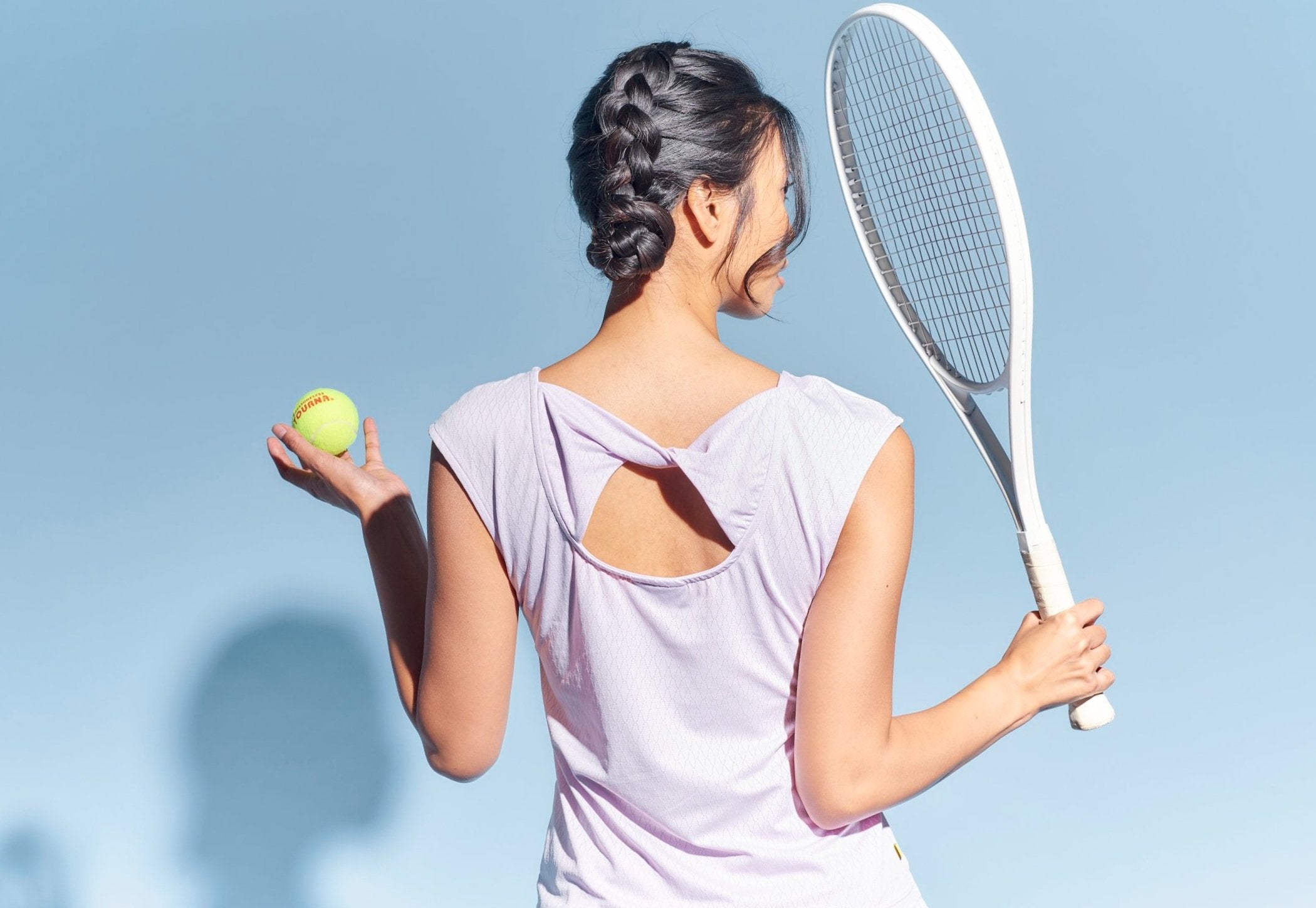 Back view of tennis player with twist back detail in lavender.