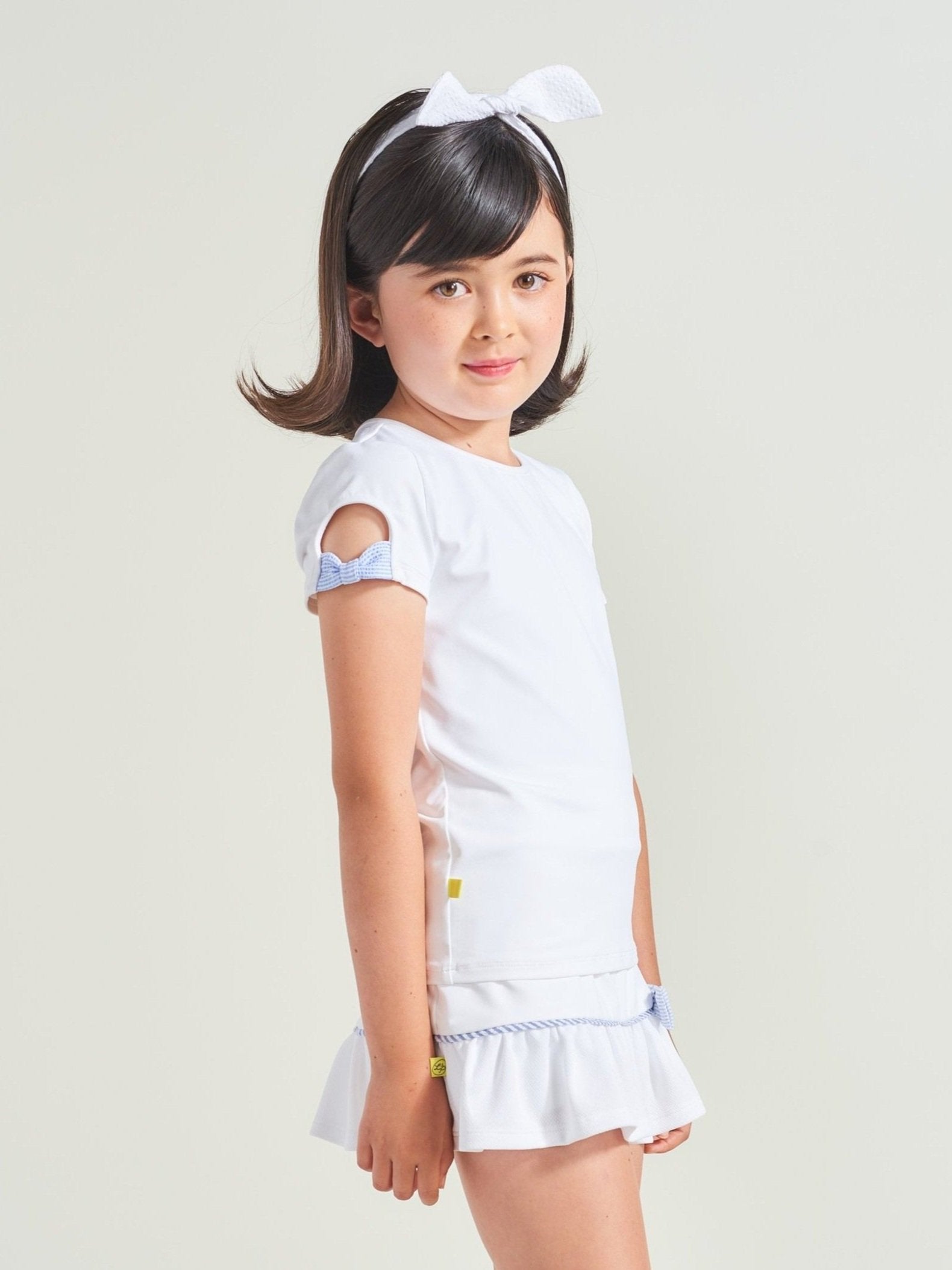 White tennis shirt for girls with blue bow details