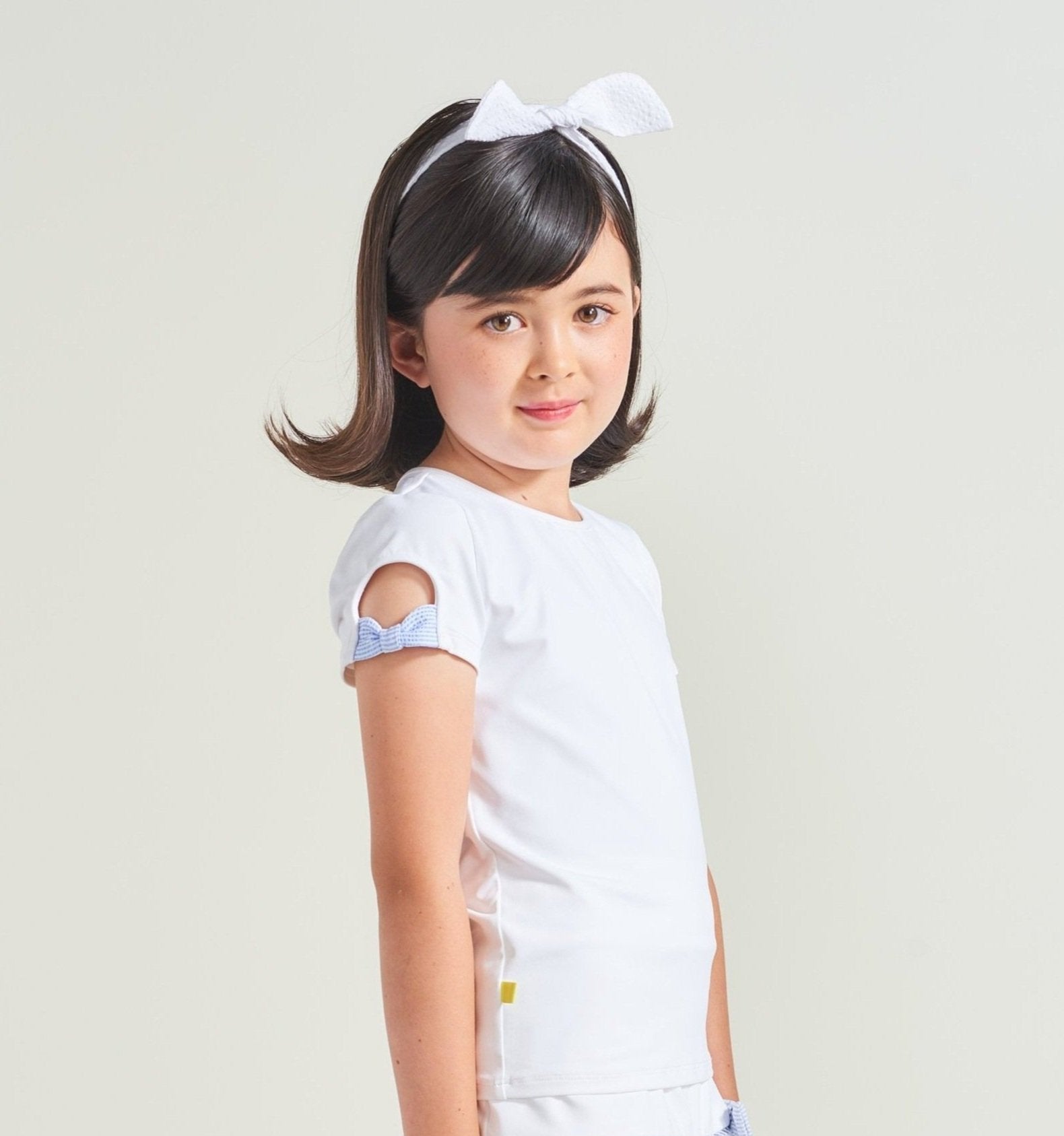 White tennis shirt for girls with blue bow details