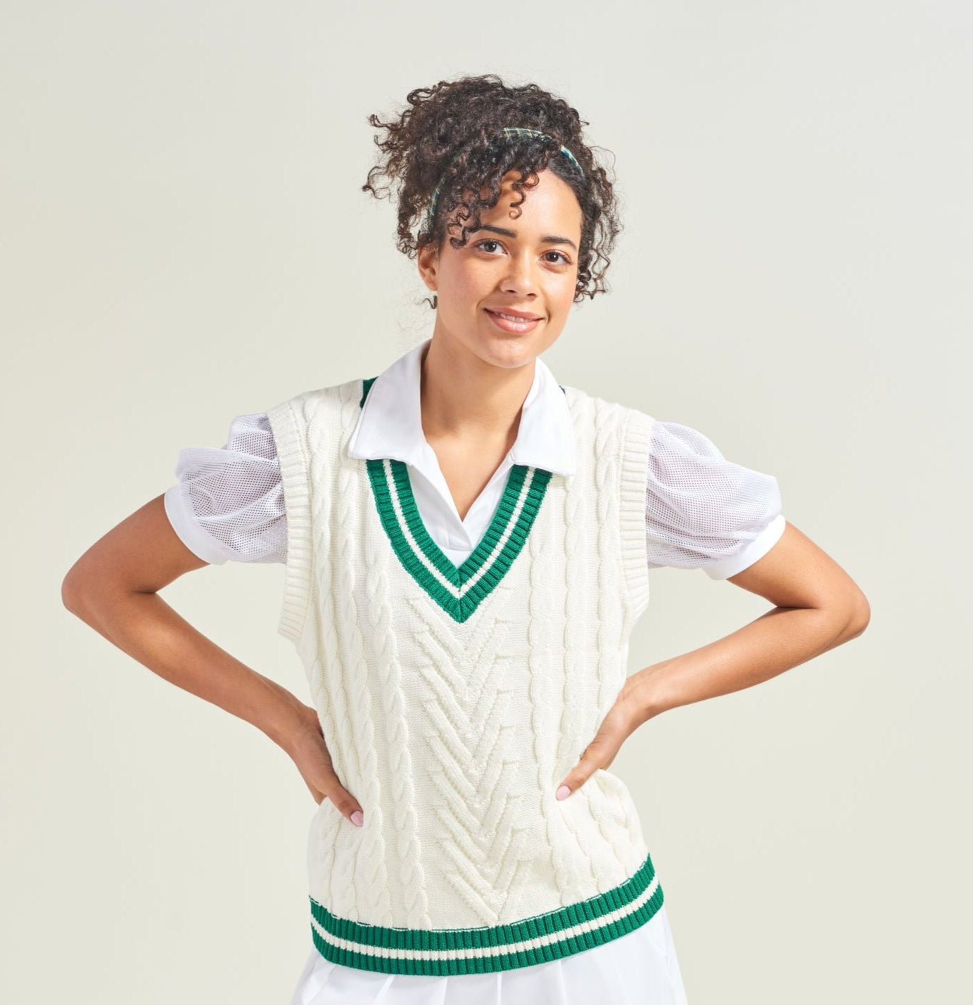 Person wearing a white and green sports uniform on a plain background
